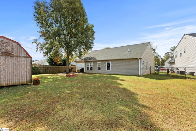 back of house featuring a shed and a lawn