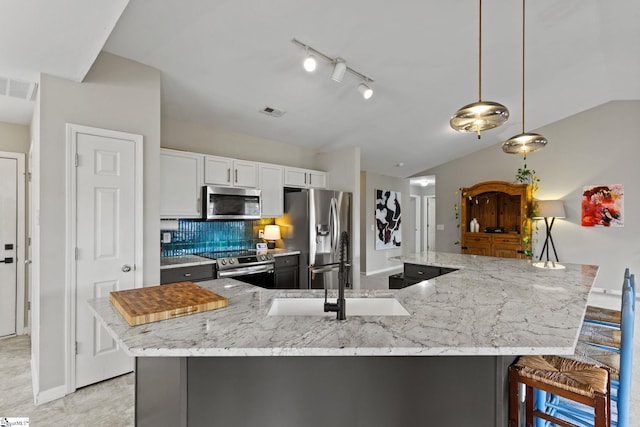 kitchen featuring a breakfast bar area, white cabinetry, hanging light fixtures, appliances with stainless steel finishes, and a large island