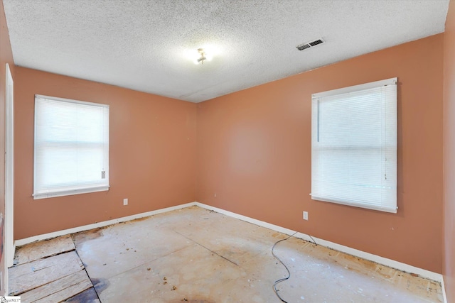 unfurnished room featuring a textured ceiling