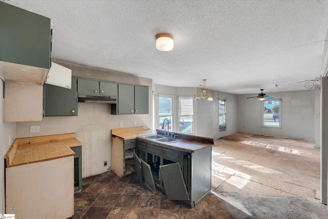 kitchen with wood counters, ceiling fan, sink, and a textured ceiling