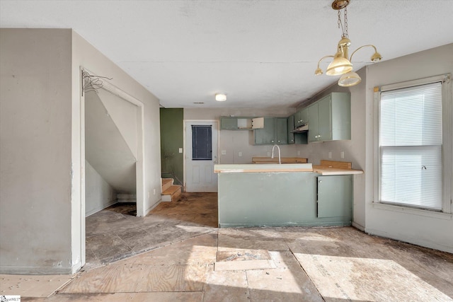 kitchen with sink, green cabinets, and a notable chandelier