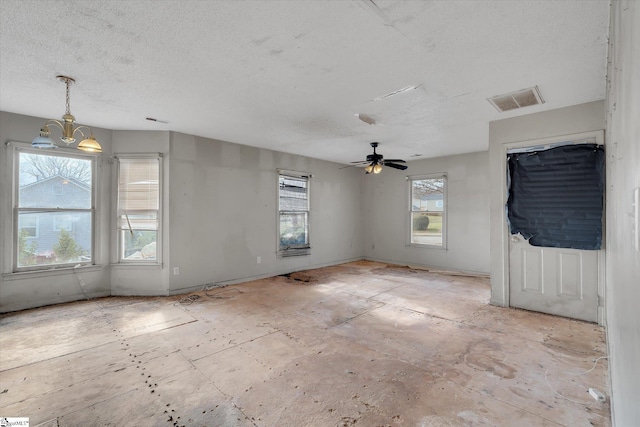 spare room with ceiling fan with notable chandelier and a textured ceiling