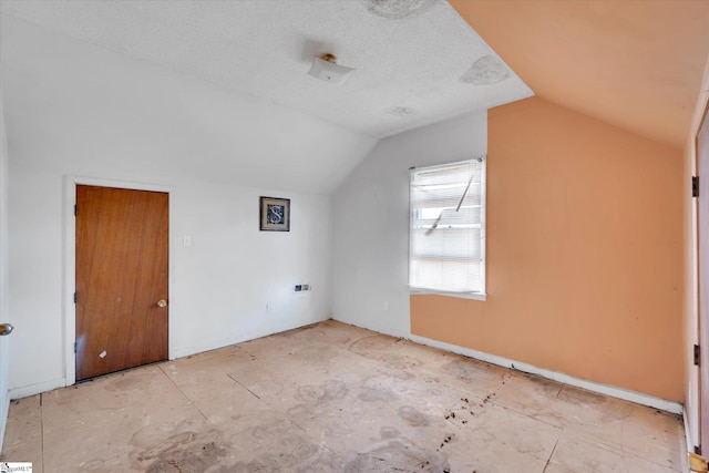 bonus room with lofted ceiling and a textured ceiling