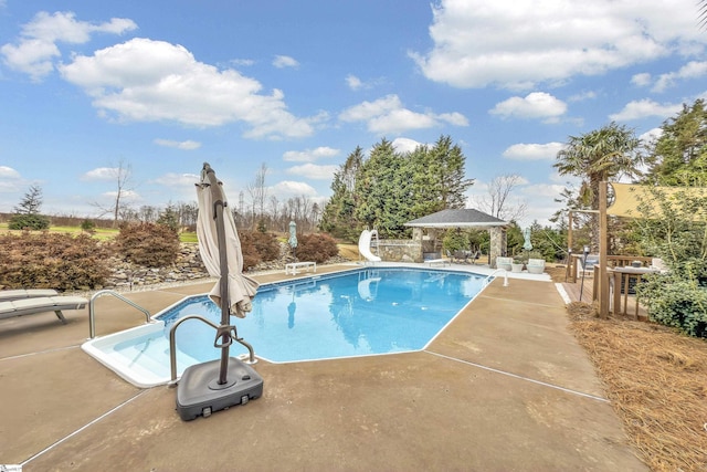 view of swimming pool featuring a gazebo, a water slide, and a patio