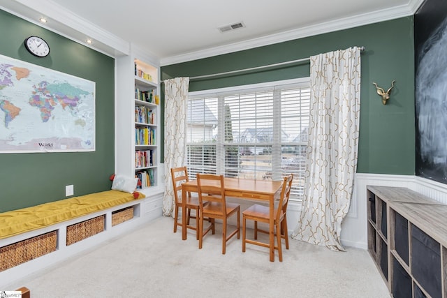 carpeted dining room featuring crown molding and built in features