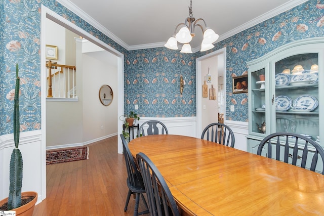 dining area featuring ornamental molding, hardwood / wood-style floors, and a notable chandelier