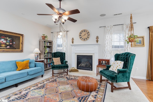 living room featuring ceiling fan, light hardwood / wood-style floors, and a wealth of natural light