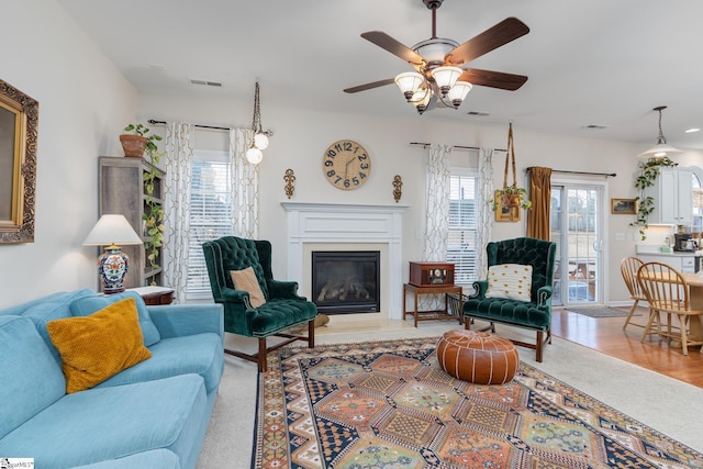 living room featuring ceiling fan and light hardwood / wood-style floors