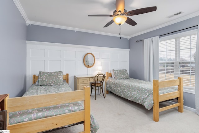 carpeted bedroom featuring crown molding and ceiling fan