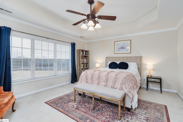 bedroom featuring crown molding, a tray ceiling, carpet floors, and ceiling fan