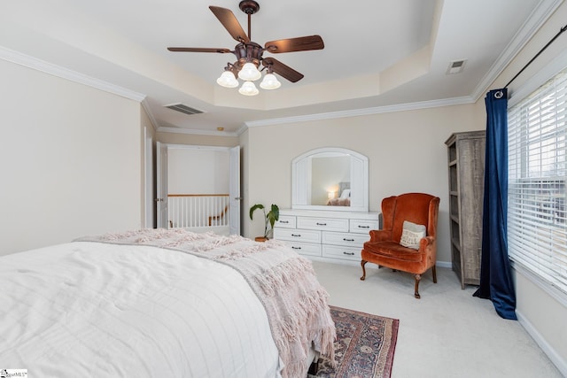 carpeted bedroom with a raised ceiling, crown molding, and ceiling fan