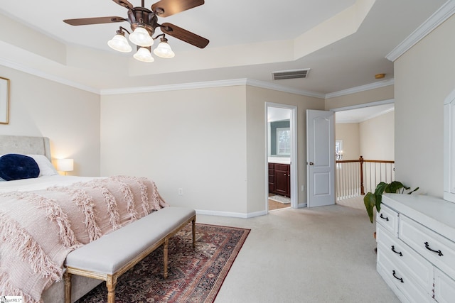 carpeted bedroom with crown molding, ceiling fan, ensuite bathroom, and a raised ceiling