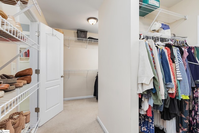 walk in closet featuring light colored carpet