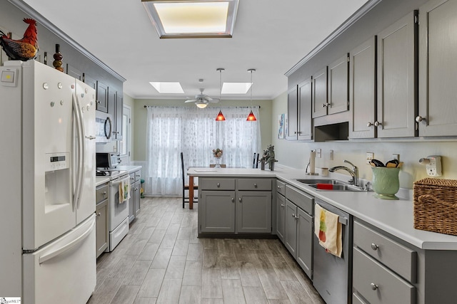 kitchen with ornamental molding, appliances with stainless steel finishes, a skylight, and kitchen peninsula