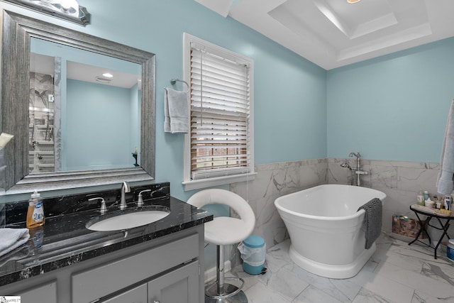 bathroom featuring vanity, a tub, and tile walls