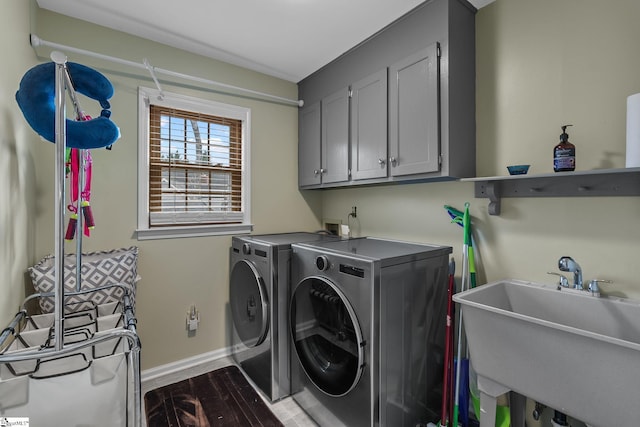 washroom featuring cabinets, dark hardwood / wood-style flooring, sink, and washer and clothes dryer