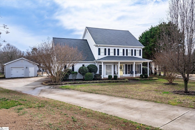 colonial-style house featuring a garage, an outdoor structure, a porch, and a front yard