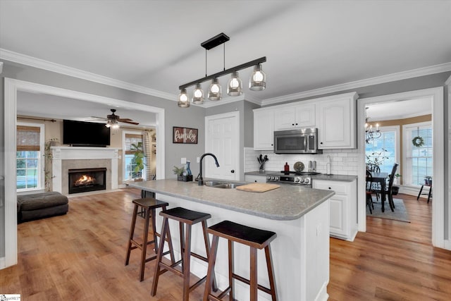 kitchen featuring white cabinetry, sink, plenty of natural light, and range