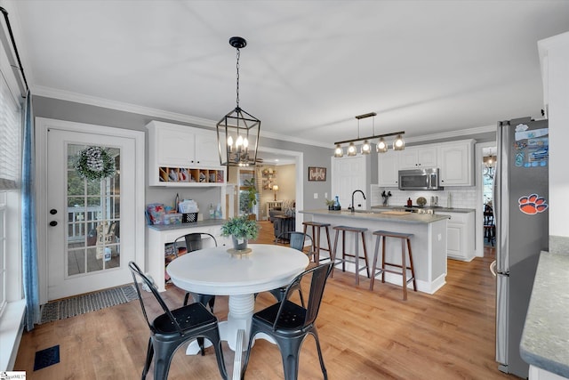 dining area with crown molding and light wood-type flooring