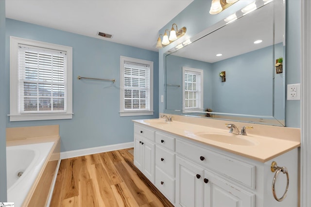 bathroom featuring vanity, hardwood / wood-style floors, and a washtub