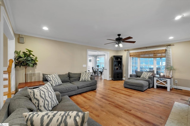 living room with light hardwood / wood-style flooring, ornamental molding, and plenty of natural light