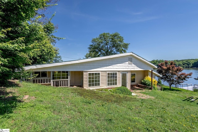 back of house featuring a yard and a water view