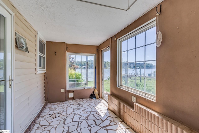 sunroom / solarium featuring a water view