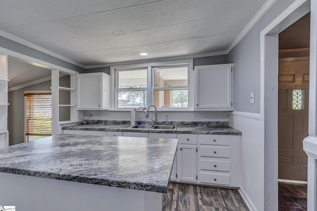 kitchen featuring dark hardwood / wood-style flooring, sink, crown molding, and white cabinets