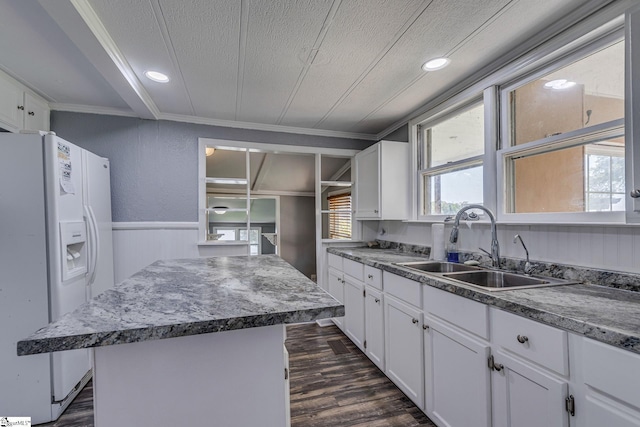 kitchen featuring sink, white cabinetry, white refrigerator with ice dispenser, ornamental molding, and a kitchen island