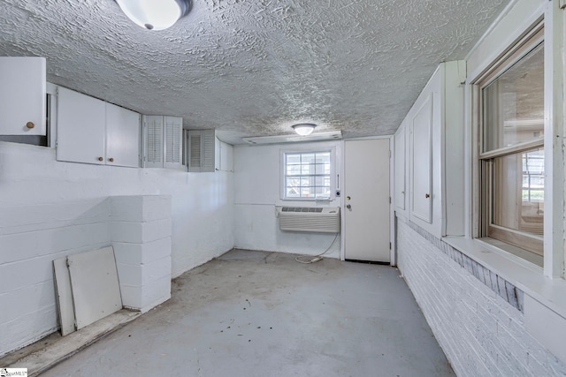 basement featuring cooling unit and a textured ceiling