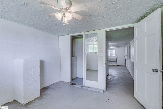 empty room with ceiling fan and a textured ceiling