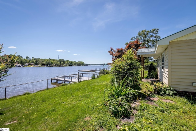 dock area featuring a lawn and a water view