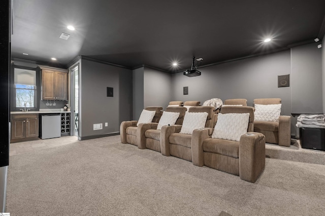 carpeted home theater featuring crown molding and bar