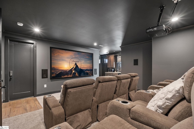 cinema room featuring crown molding and light hardwood / wood-style flooring