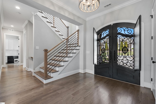 foyer featuring french doors, a notable chandelier, ornamental molding, and hardwood / wood-style flooring