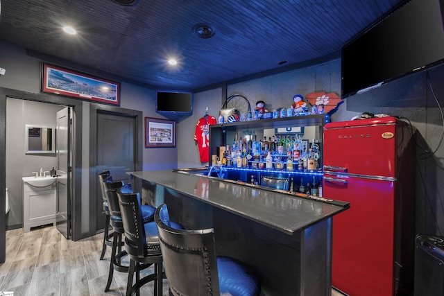 bar featuring sink, wood ceiling, light hardwood / wood-style floors, and refrigerator