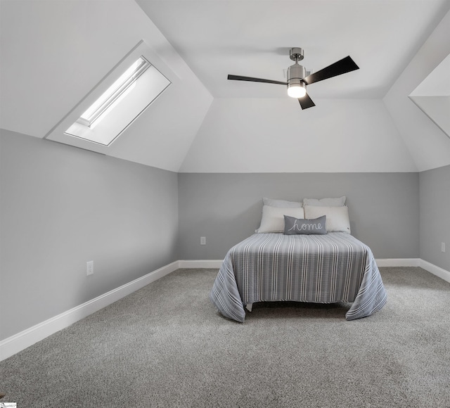 carpeted bedroom featuring vaulted ceiling with skylight and ceiling fan