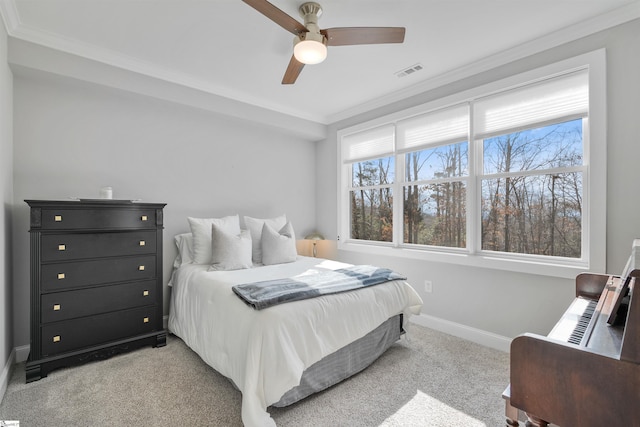 carpeted bedroom with ornamental molding and ceiling fan