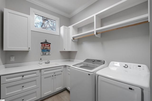 washroom featuring cabinets, ornamental molding, sink, and washing machine and dryer