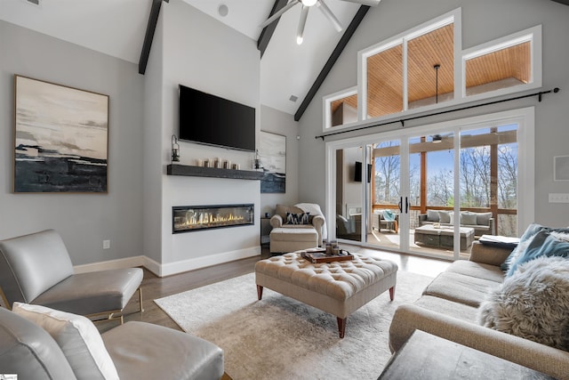 living room featuring beam ceiling, wood-type flooring, high vaulted ceiling, and ceiling fan