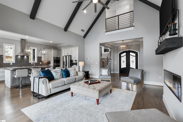 living room with high vaulted ceiling, beamed ceiling, hardwood / wood-style flooring, crown molding, and french doors