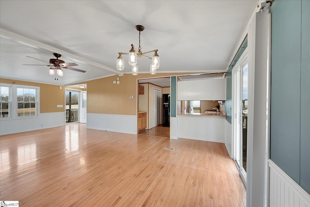 unfurnished living room featuring ceiling fan with notable chandelier, ornamental molding, and light hardwood / wood-style floors