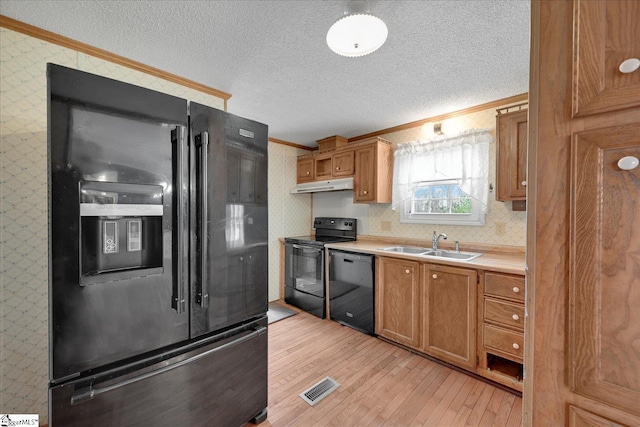 kitchen with ornamental molding, sink, a textured ceiling, and black appliances