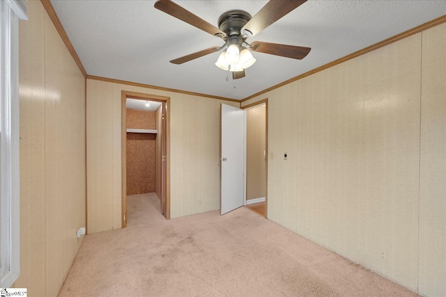 unfurnished bedroom featuring light carpet, crown molding, a closet, and a textured ceiling