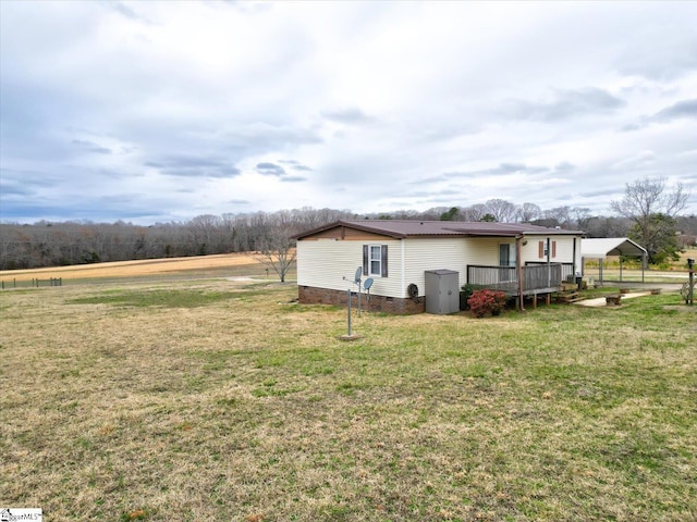 view of home's exterior with a carport, a yard, and a deck