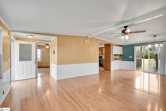 unfurnished living room with ceiling fan, ornamental molding, light hardwood / wood-style floors, and vaulted ceiling with beams