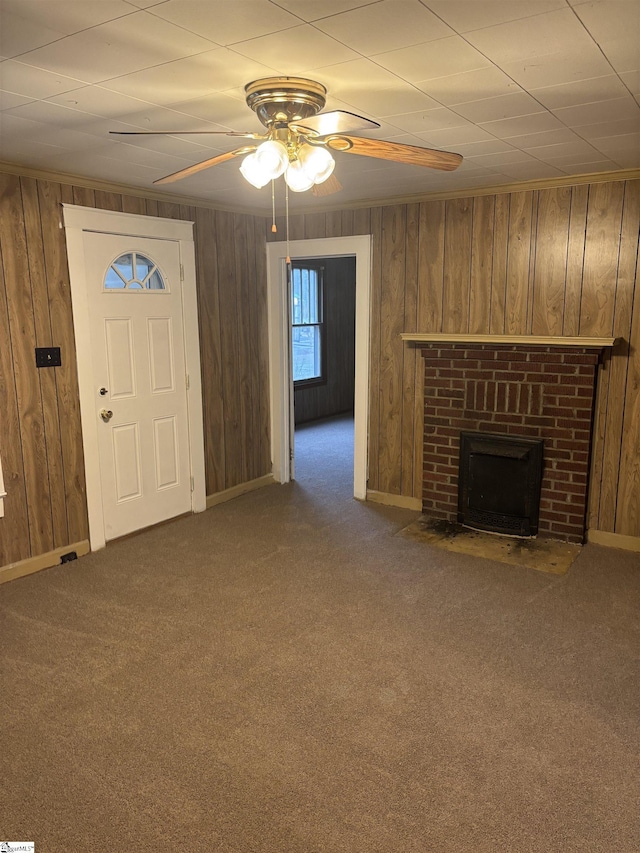 unfurnished living room with carpet flooring, a brick fireplace, and wood walls