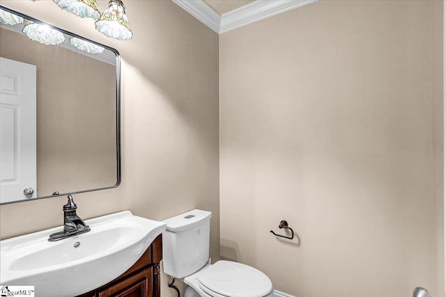 bathroom with vanity, crown molding, and toilet