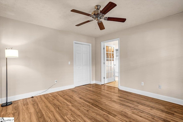 unfurnished room with hardwood / wood-style flooring, ceiling fan, and a textured ceiling