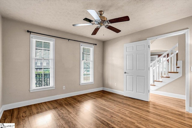 spare room with ceiling fan, light hardwood / wood-style flooring, and a textured ceiling